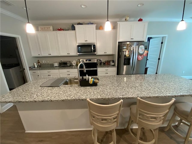 kitchen with appliances with stainless steel finishes, hanging light fixtures, and white cabinets