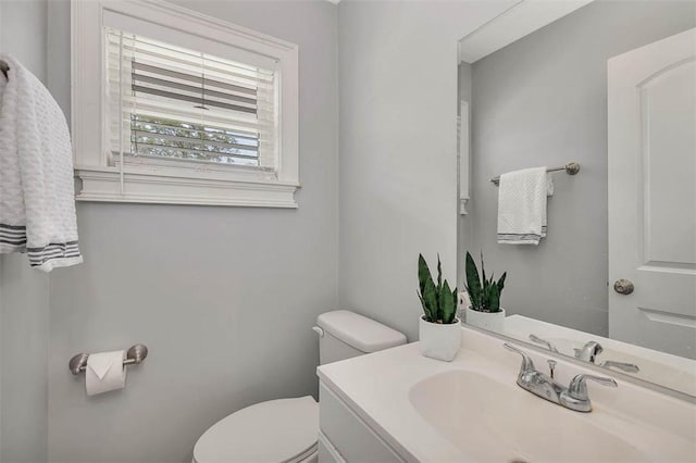 half bathroom with vanity and toilet