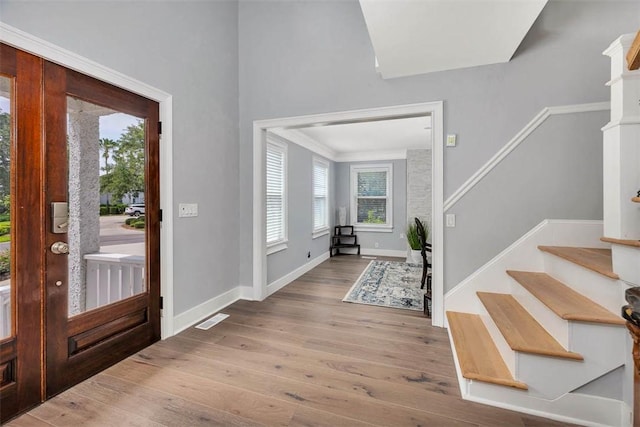 entryway featuring stairway, visible vents, light wood-style flooring, and baseboards