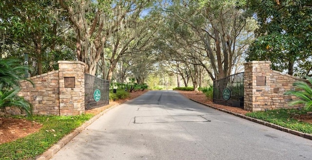 view of street with a gate and curbs