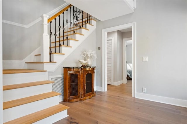 stairs featuring wood finished floors and baseboards