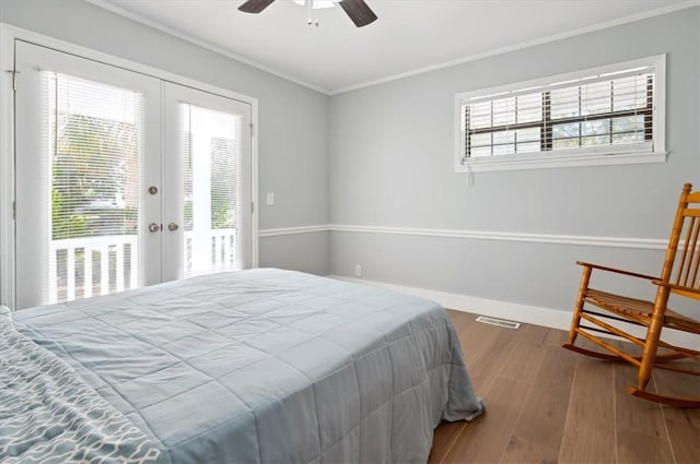 bedroom featuring access to exterior, french doors, ornamental molding, wood finished floors, and baseboards