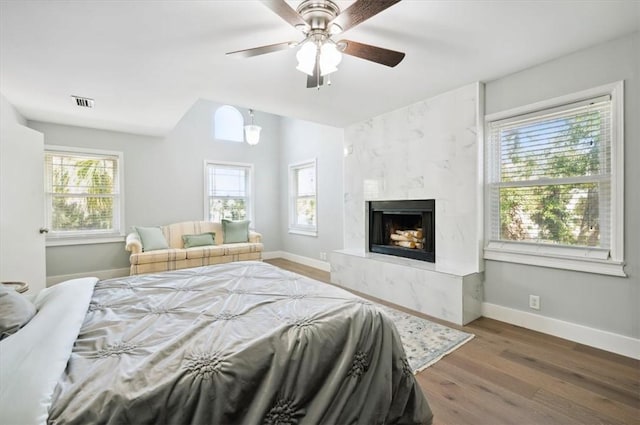 bedroom with visible vents, dark wood-style flooring, a high end fireplace, and baseboards