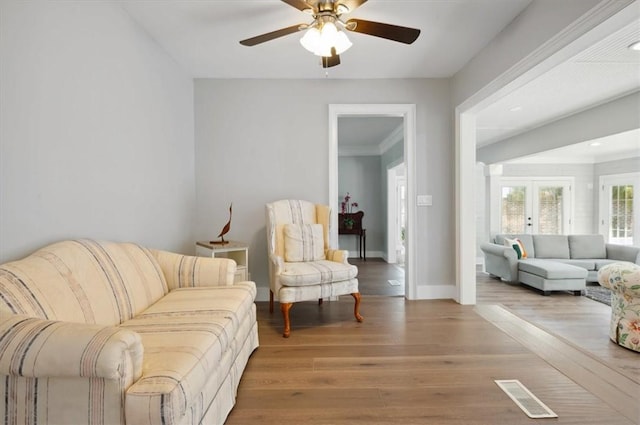 sitting room featuring baseboards, visible vents, a ceiling fan, wood finished floors, and french doors