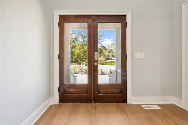 entryway featuring baseboards, visible vents, wood finished floors, and french doors