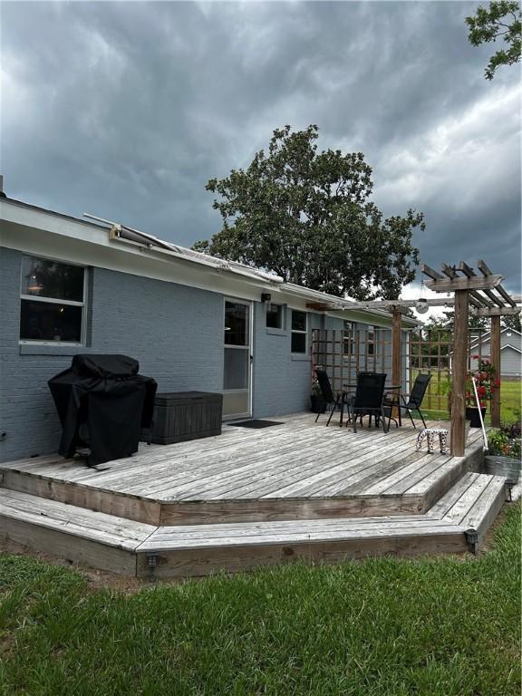 604 E Waring St, Waycross, GA 31501 - back of property featuring brick siding, a wooden deck, and outdoor dining area