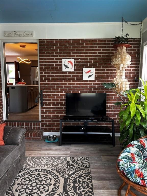 604 E Waring St, Waycross, GA 31501 - living room featuring wood finished floors and brick wall
