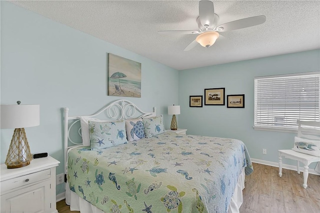 bedroom featuring a textured ceiling, light hardwood / wood-style flooring, and ceiling fan