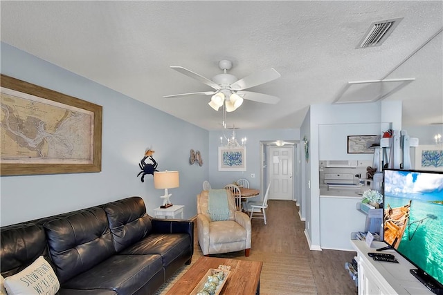 living room featuring ceiling fan with notable chandelier, wood-type flooring, and a textured ceiling