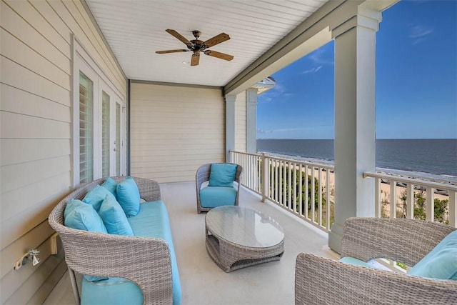 balcony featuring ceiling fan, a water view, and a beach view