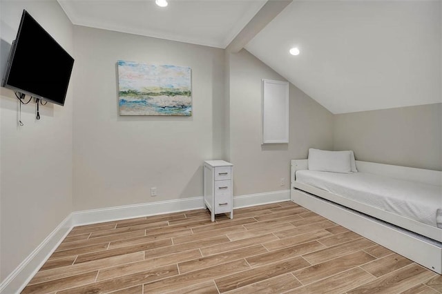 unfurnished bedroom featuring vaulted ceiling with beams and light hardwood / wood-style flooring