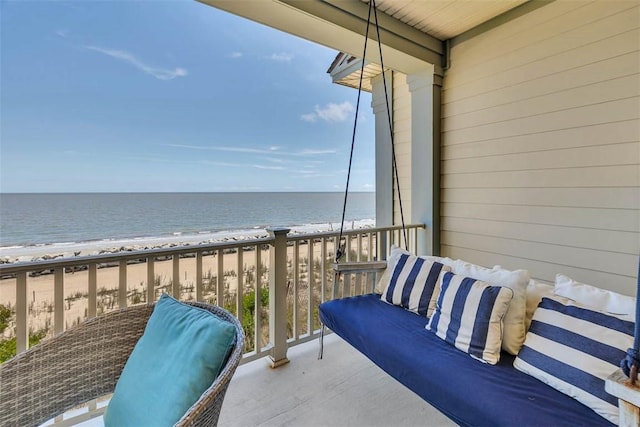 balcony with a water view and a view of the beach