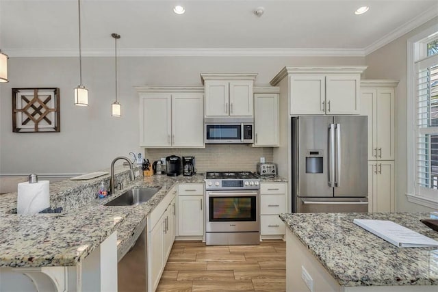 kitchen with sink, stainless steel appliances, crown molding, pendant lighting, and light wood-type flooring