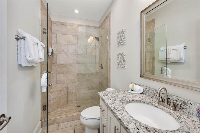 bathroom featuring tile patterned floors, toilet, vanity, and walk in shower