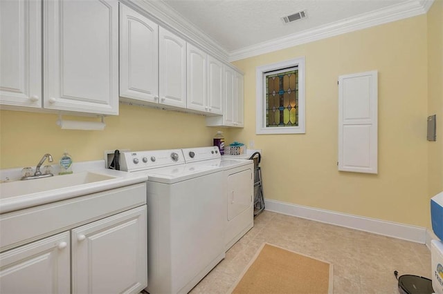 clothes washing area with visible vents, crown molding, washing machine and dryer, baseboards, and cabinet space