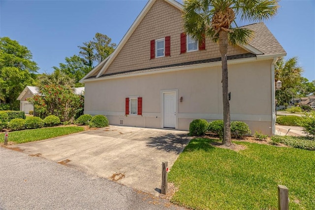 view of side of property featuring a yard and stucco siding