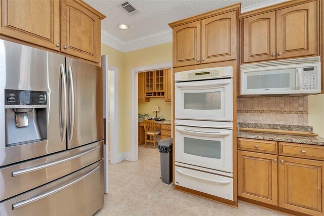 kitchen featuring white appliances, backsplash, visible vents, ornamental molding, and a warming drawer