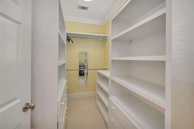 walk in closet featuring light colored carpet and visible vents