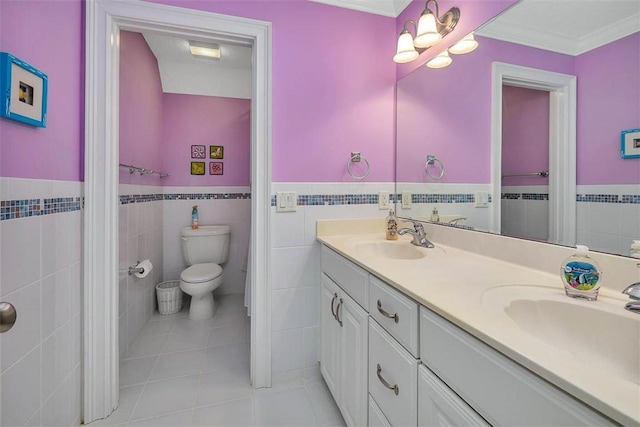 bathroom featuring double vanity, a sink, wainscoting, and tile walls