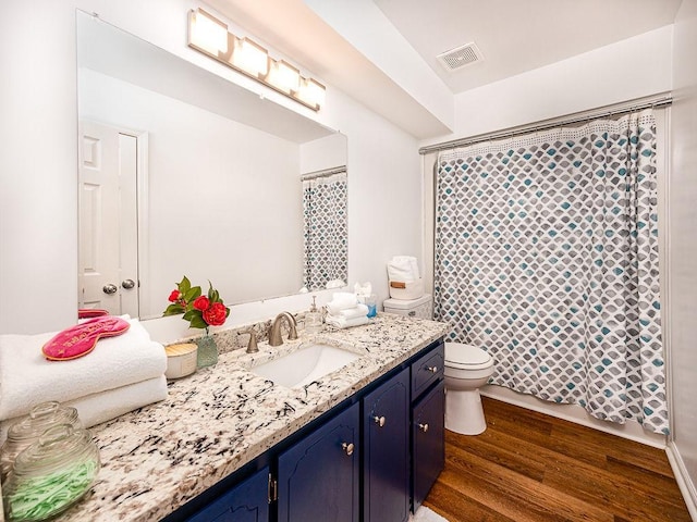 bathroom featuring vanity, hardwood / wood-style floors, toilet, and walk in shower