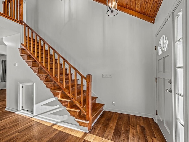 entrance foyer featuring beamed ceiling, dark wood-type flooring, wooden ceiling, and high vaulted ceiling