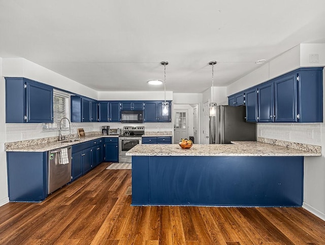 kitchen featuring sink, blue cabinetry, appliances with stainless steel finishes, dark hardwood / wood-style floors, and kitchen peninsula