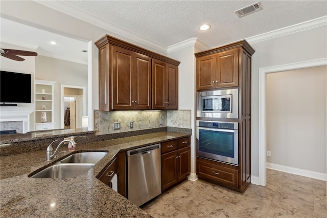kitchen featuring a sink, stainless steel appliances, dark stone countertops, and visible vents