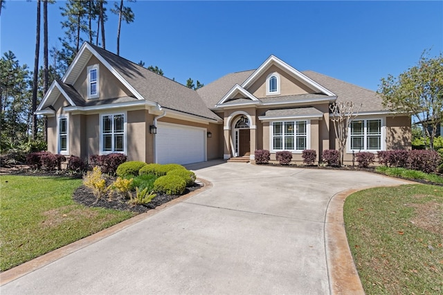 craftsman-style house with a garage, concrete driveway, a front lawn, roof with shingles, and stucco siding