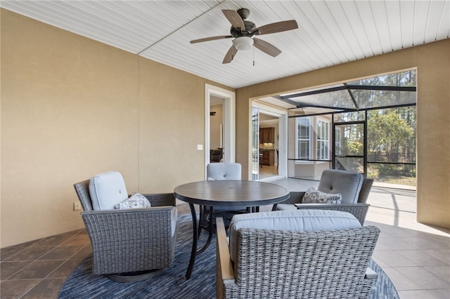 sunroom / solarium featuring a ceiling fan and outdoor dining space