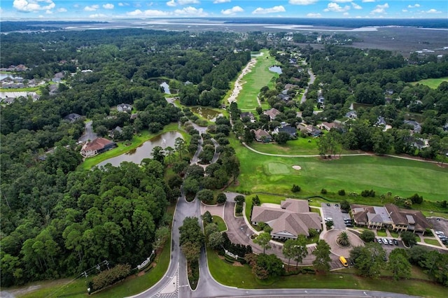 drone / aerial view featuring a water view, golf course view, and a forest view