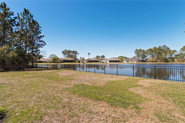 view of yard featuring a water view and fence