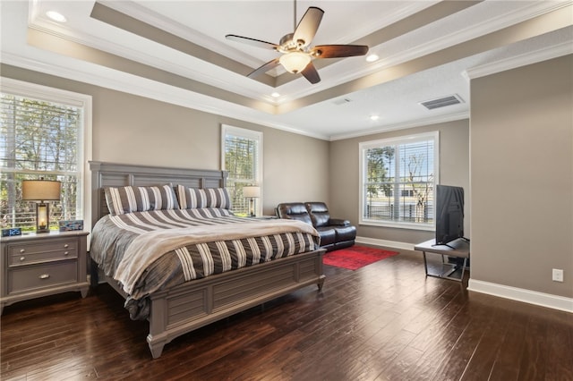bedroom featuring a raised ceiling, dark wood-style flooring, multiple windows, and visible vents