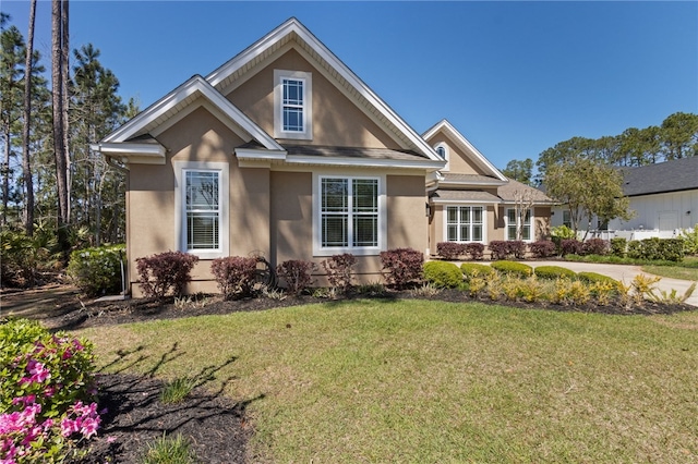 craftsman-style house featuring stucco siding and a front lawn