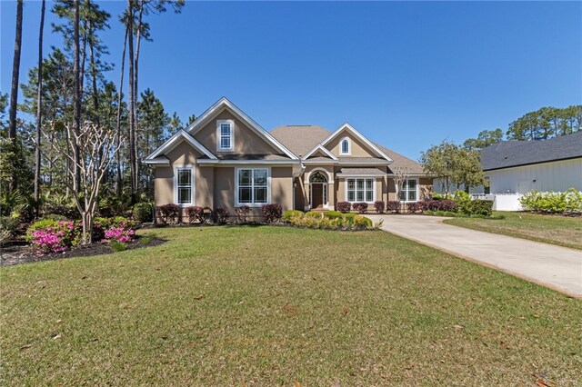 craftsman house with a front yard and stucco siding