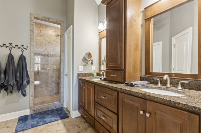 full bath with double vanity, a sink, baseboards, and a tile shower