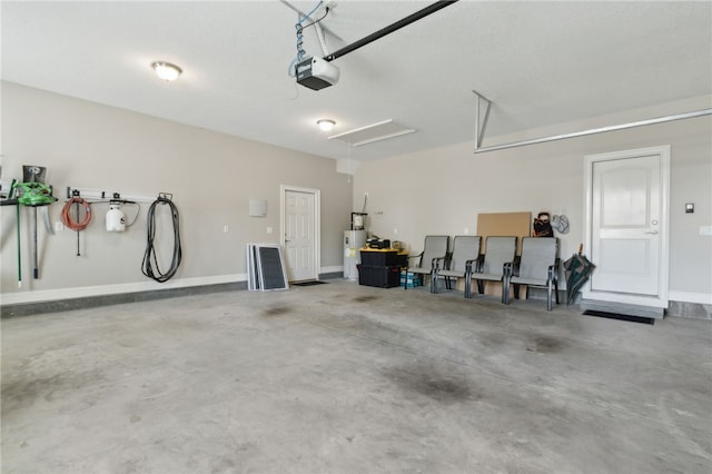 garage with water heater, a garage door opener, and baseboards