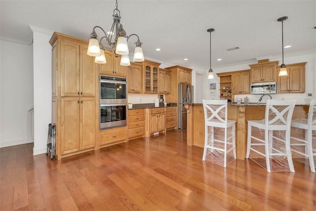 17 Willow Ct, Brunswick, GA 31523 - kitchen featuring stainless steel appliances, ornamental molding, glass insert cabinets, a breakfast bar area, and wood finished floors