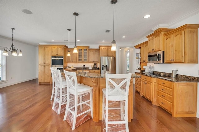 17 Willow Ct, Brunswick, GA 31523 - kitchen with appliances with stainless steel finishes, wood finished floors, crown molding, plenty of natural light, and glass insert cabinets