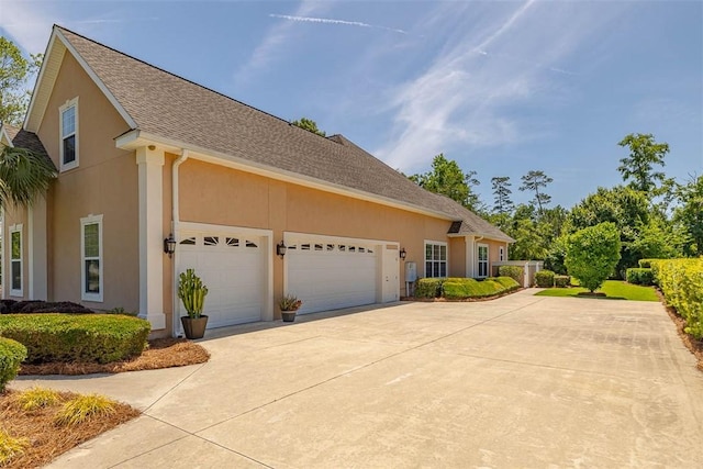 17 Willow Ct, Brunswick, GA 31523 - view of front of house with driveway, an attached garage, stucco siding, and roof with shingles