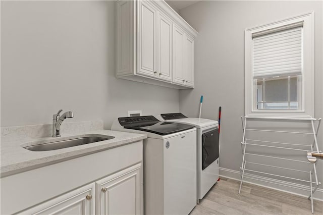 107 Cason Noah Dr, Kingsland, GA 31548 - clothes washing area featuring washer and clothes dryer, light hardwood / wood-style floors, cabinets, and sink