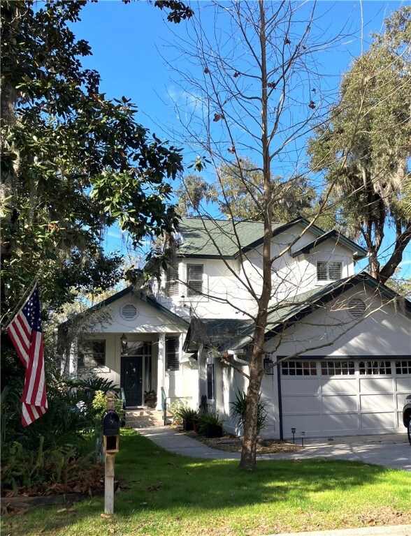 view of property hidden behind natural elements featuring a garage