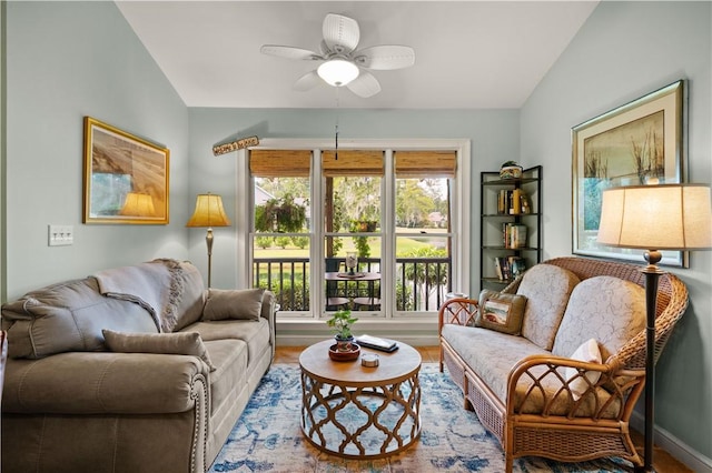 living room with ceiling fan, lofted ceiling, and hardwood / wood-style flooring