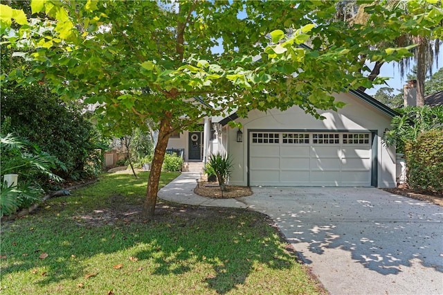 view of property hidden behind natural elements with an attached garage, a chimney, concrete driveway, and stucco siding