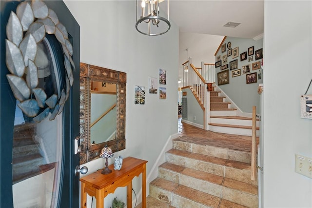 stairway featuring a notable chandelier