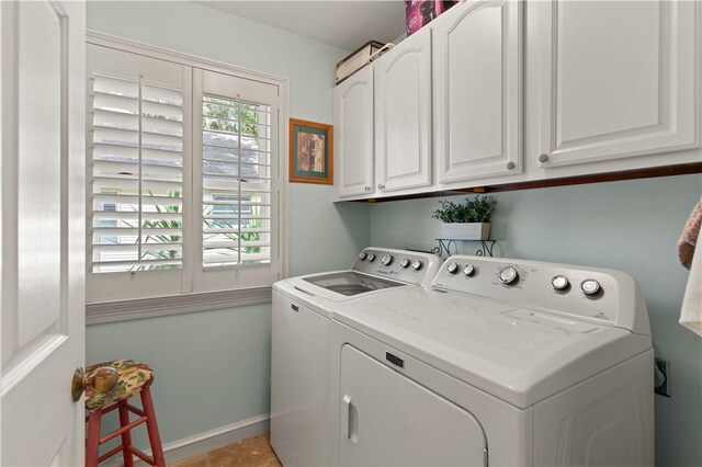 laundry area with washing machine and clothes dryer and cabinets