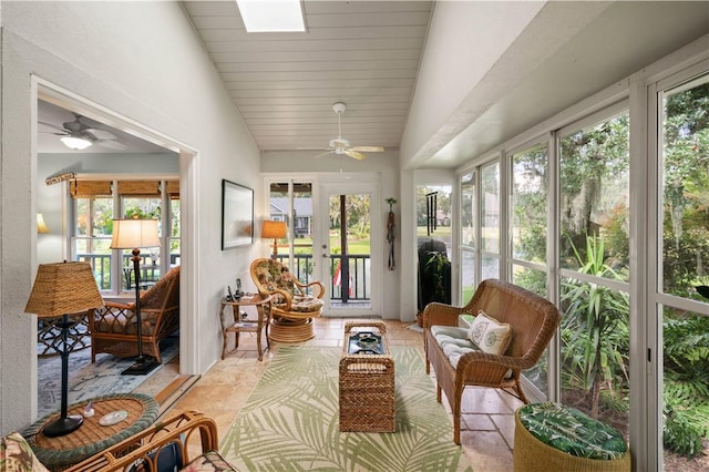 sunroom featuring vaulted ceiling with skylight, plenty of natural light, ceiling fan, and french doors