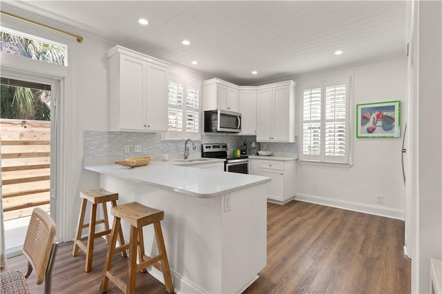 kitchen featuring white cabinets, stainless steel appliances, and a wealth of natural light