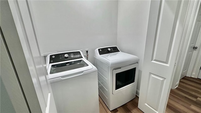 washroom featuring dark hardwood / wood-style flooring and washing machine and clothes dryer