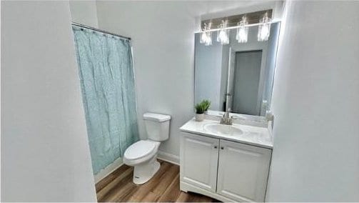 bathroom featuring hardwood / wood-style floors, vanity, and toilet