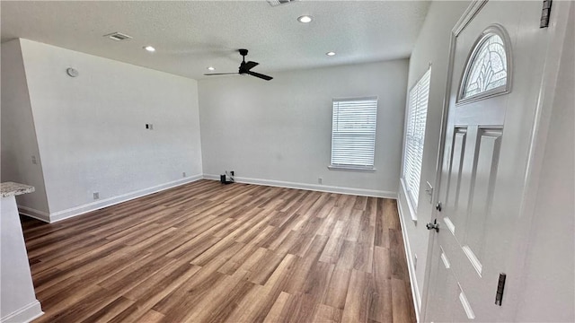 interior space with ceiling fan, a textured ceiling, and hardwood / wood-style flooring